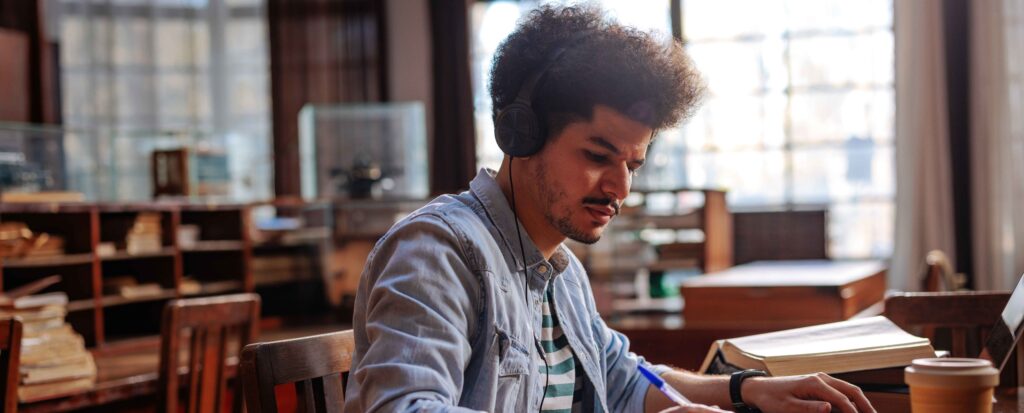 student studying in library wearing headphones