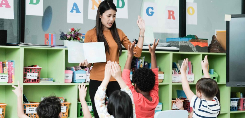 teacher standing in front of her class with an open book